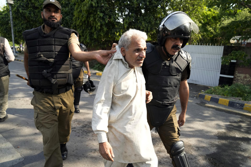 Police detain a supporter of Pakistan's former Prime Minister Imran Khan who along with others are protesting against the arrest of their leader, in Lahore, Pakistan, Wednesday, May 10, 2023. Khan can be held for eight days, a court ruled Wednesday, a day after the popular opposition leader was dragged from a courtroom and arrested on corruption charges, deepening the country's political turmoil. (AP Photo/K.M. Chaudary)