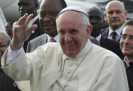 Pope Francis (R), followed by Kenya's President Uhuru Kenyatta, waves as he arrives at the international airport in Nairobi on November 25, 2015