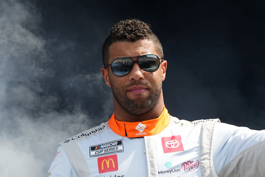 Bubba Wallace waves to fans as he walks onstage during driver intros