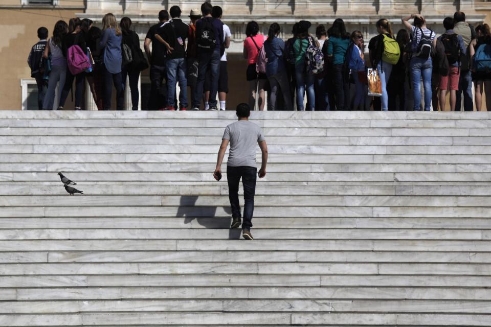 A pedestrian walks up the steps of Syntagma square in Athens on Wednesday, April 9, 2014. Greece confirmed Wednesday that it is returning to international bond markets for the first time in four years amid growing signs of confidence in the country. (AP Photo/Kostas Tsironis)