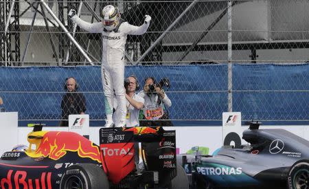 Formula One - F1 - Mexican F1 Grand Prix - Mexico City, Mexico - 30/10/16 - Mercedes' Lewis Hamilton of Britain celebrates his race victory atop a competitor's car. REUTERS/Henry Romero