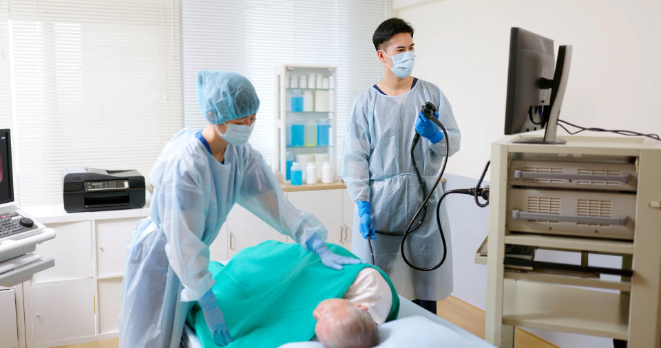 Two healthcare workers with a patient preparing for a medical procedure in a clinic