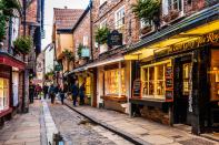 The buildings that line Shambles—a street in York, England—were erected as far back as the 14th century. The charming timber-framed buildings bend and, at times, hang over the cobblestoned street below.