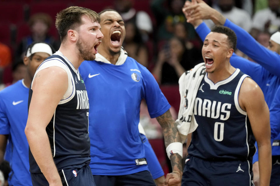 Dallas Mavericks guard Luka Doncic, left, reacts after making a basket and drawing a foul by the Houston Rockets during the first half of an NBA basketball game Sunday, March 31, 2024, in Houston. (AP Photo/Eric Christian Smith)