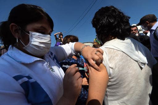 Voluntarios son vacunados contra el tétanos el 14 de abril en la zona incendiada de Valparaíso en Chile (AFP | Martín Bernetti)