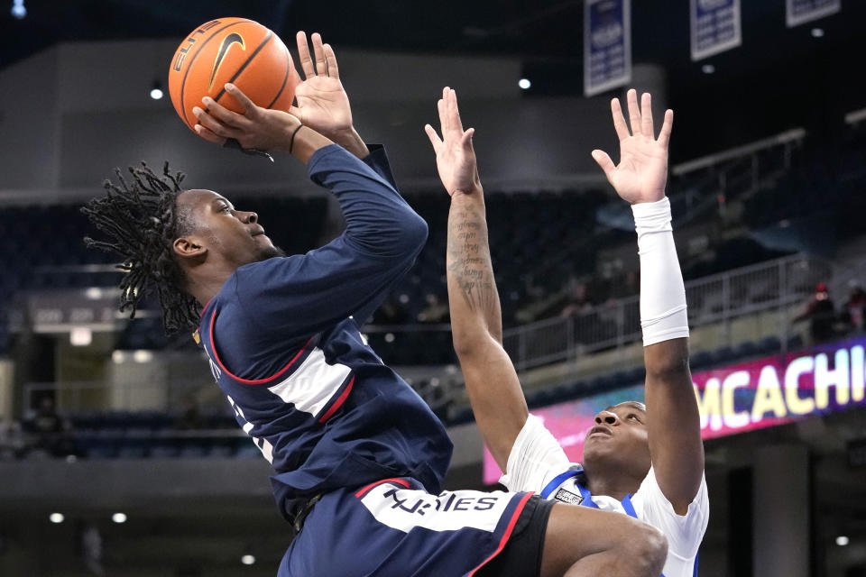 UConn guard Tristen Newton, left, drives to the basket against DePaul guard Elijah Fisher during the first half of an NCAA college basketball game in Chicago, Wednesday, Feb. 14, 2024. (AP Photo/Nam Y. Huh)