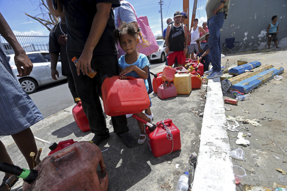 Abi de la Paz de la Cruz, 3, holds a gas can as she waits in line with her family, San Juan, Puerto Rico, Sept. 25, 2017. (Photo: Gerald Herbert/AP)