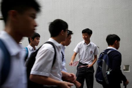 Secondary school student Parco Wong Lok-hang (2nd-R), 17, hands out leaflets in school to promote Hong Kong's independence during the first day of academic year in Hong Kong, China, September 1, 2016. REUTERS/Tyrone Siu