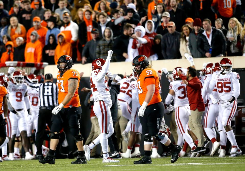 OU's David Ugwoegbu (34) celebrates an interception in the fourth quarter as OSU's Teven Jenkins (73) and Relijah Sherman (50) walk off the field in a 34-16 Sooners win in Stillwater on Nov. 30, 2019.