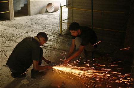 Palestinian labourers work inside a building which is under construction in Gaza City September 22, 2013. REUTERS/Mohammed Salem