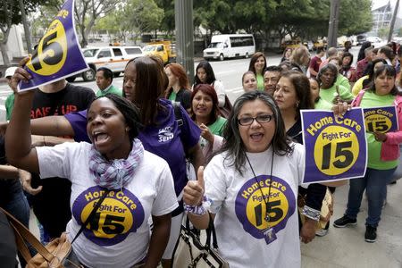 People demonstrate outside City Hall before the Los Angeles City Council approved a proposal to raise the minimum wage to $15.00 per hour in Los Angeles, California June 3, 2015. REUTERS/Jonathan Alcorn
