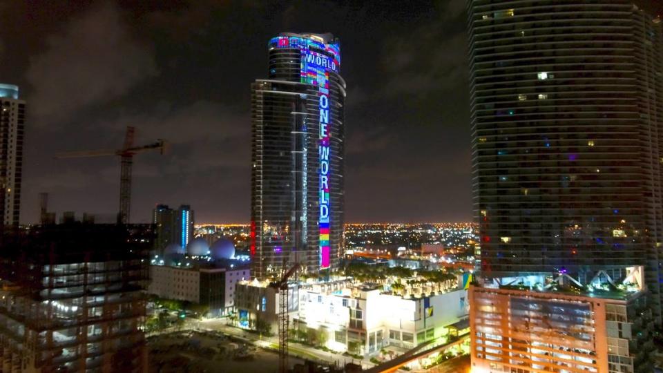 The 60-story Paramount Miami Worldcenter at 851 NE First Ave in Downtown Miami, will light up every night with hundreds of fluttering flags and the words “One World, One Prayer,” until all of the missing people in Surfside’s building collapse are found. Pictured above is a May 19, 2020 photo when the skyscraper was lit up during the week of the 39th annual funeral observance of music legend Bob Marley. (Bryan Glazer/World Satellite Television News via AP Images)