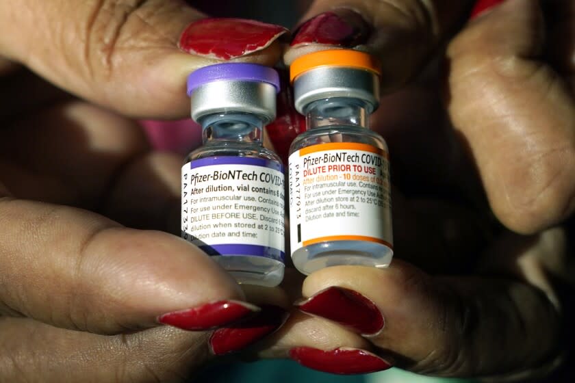 FILE - A nurse holds a vial of the Pfizer COVID-19 vaccine for children ages 5 to 11, right, and a vial of the vaccine for adults, which has a different colored label, at a vaccination station in Jackson, Miss., Tuesday, Feb. 8, 2022. (AP Photo/Rogelio V. Solis, File)