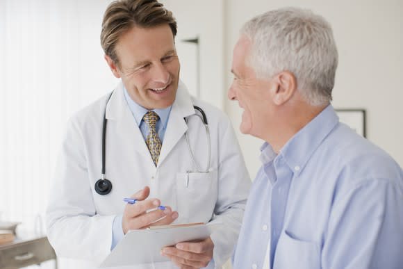 A smiling doctor having a discussion with an elderly patient.