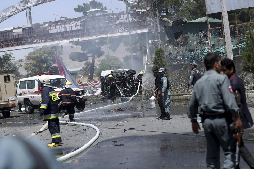 FILE - Afghan fire fighters extinguish vehicles on fire after an attack at the main gate of International Hamed Karzai Airport in Kabul, Afghanistan, Aug. 10, 2015. At a time when Americans are deeply divided along party lines, a new poll shows agreement on at least one issue: the United.States' two-decade long war in Afghanistan was not worth fighting. (AP Photo/Massoud Hossaini, File)