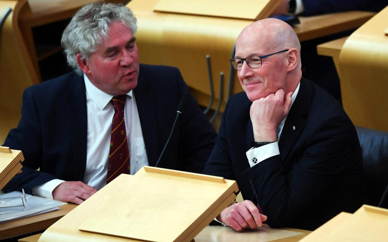John Swinney (right), the former deputy first minister of Scotland, is pictured this afternoon at Holyrood in Edinburgh