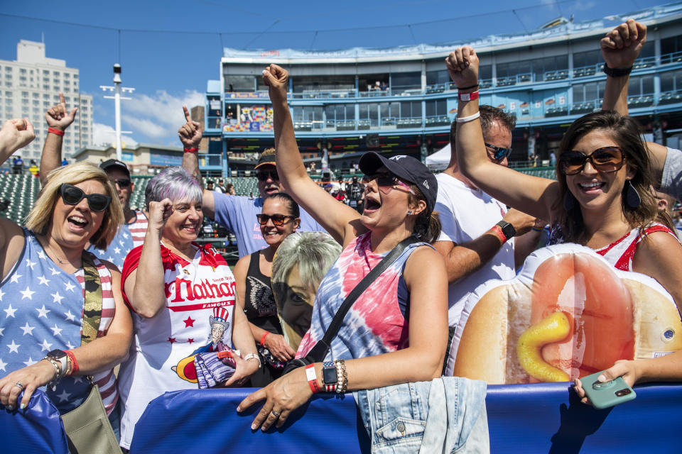 Fans cheer on contestant Larell Marie Mele, left, before going onstage at the Nathan's Famous Fourth of July International Hot Dog-Eating Contest in Coney Island's Maimonides Park on Sunday, July 4, 2021, in the Brooklyn borough of New York. (AP Photo/Brittainy Newman)
