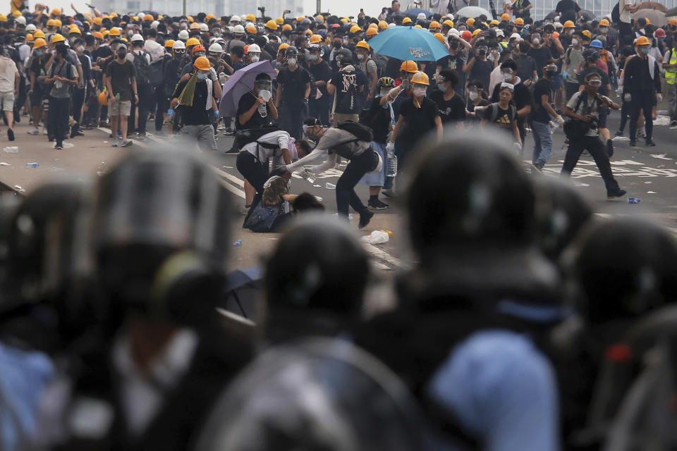 Protesters help a fallen person after clashing with riot police during a massive demonstration outside the Legislative Council in Hong Kong, Wednesday, June 12, 2019. Hong Kong police fired tear gas and rubber bullets at protesters who had massed outside government headquarters Wednesday in opposition to a proposed extradition bill that has become a lightning rod for concerns over greater Chinese control and erosion of civil liberties in the territory. (AP Photo/Kin Cheung)
