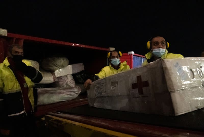 Workers unload a shipment of humanitarian aid from a plane arriving from Russia at Zvartnots airport outside Yerevan