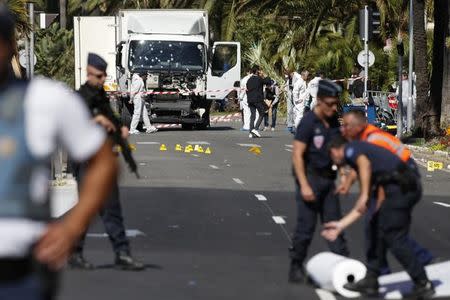 French police secure the area as the investigation continues at the scene near the heavy truck that ran into a crowd at high speed killing scores who were celebrating the Bastille Day July 14 national holiday on the Promenade des Anglais in Nice, France, July 15, 2016. REUTERS/Eric Gaillard