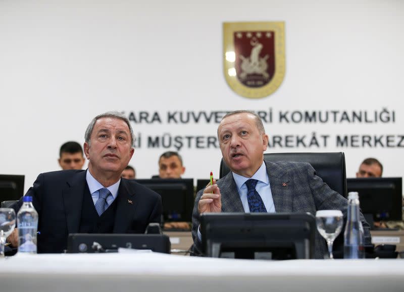 FILE PHOTO: Turkish President Tayyip Erdogan and Defence Minister Hulusi Akar attend a briefing at the Land Forces' Forward Joint Operation Command Center in Sanlıurfa