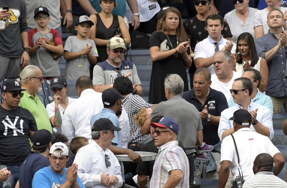 Fans react as a young girl is carried out of the seating area after being hit by a line drive at Yankee Stadium. (AP)