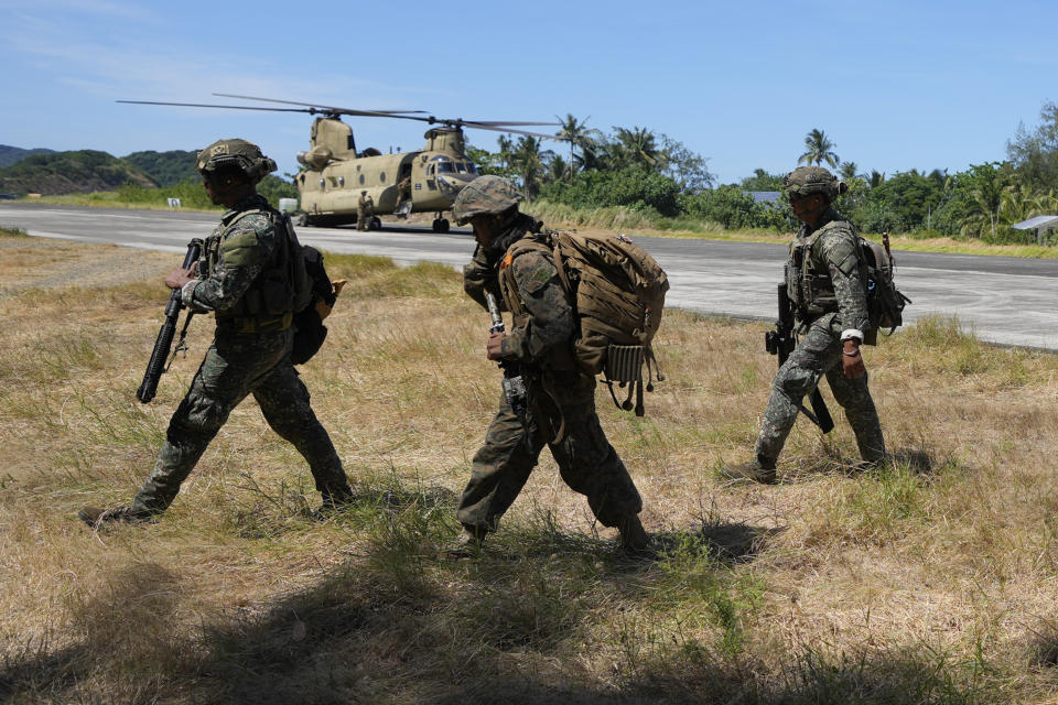 Filipino troopers walk beside a U.S. CH-47 helicopter inside the Naval Base Camilo Osias in Santa Ana, Cagayan province, northern Philippines after participating in joint military exercises on Monday, May 6, 2024. The United States and the Philippines, which are longtime treaty allies, have identified the far-flung coastal town of Santa Ana in the northeastern tip of the Philippine mainland as one of nine mostly rural areas where rotating batches of American forces could encamp indefinitely and store their weapons and equipment within local military bases under the Enhanced Defense Cooperation Agreement, or EDCA. (AP Photo/Aaron Favila)