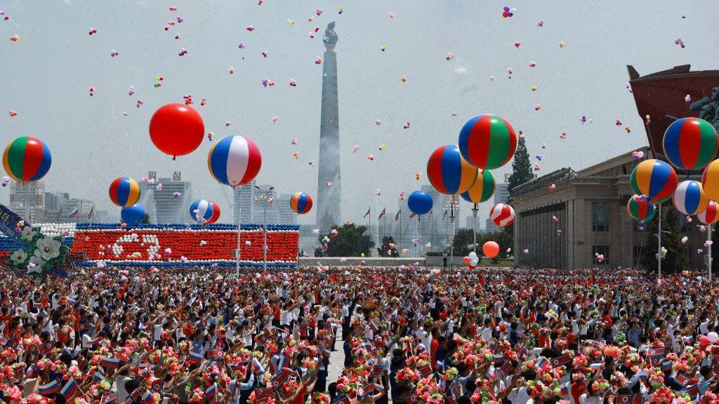 In this pool photograph distributed by the Russian state agency Sputnik, people release balloons in the air as Russia's President Vladimir Putin and North Korea's leader Kim Jong Un attend a welcoming ceremony at Kim Il Sung Square in Pyongyang on June 19, 2024.