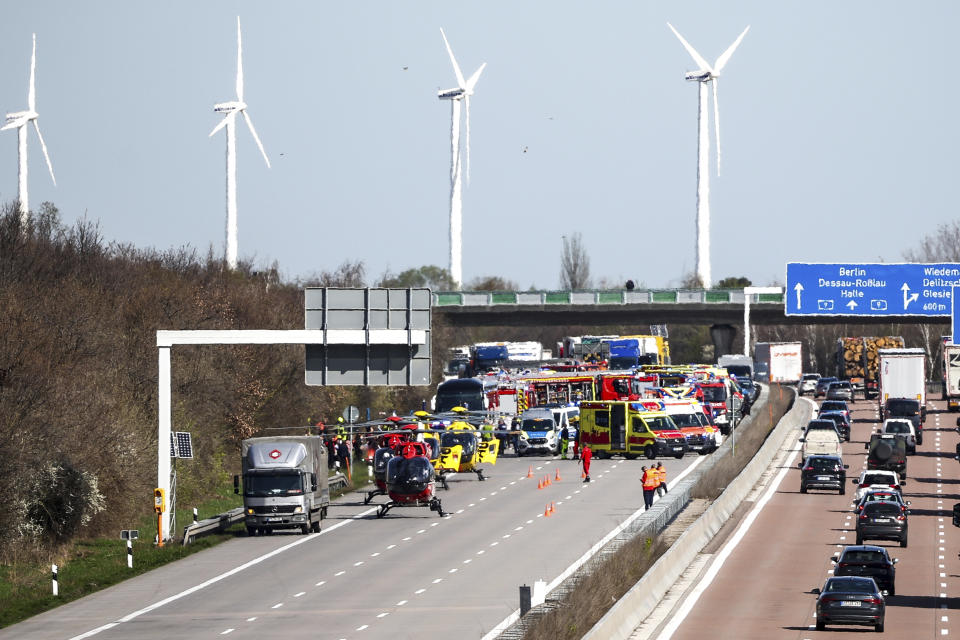 Emergency vehicles and rescue helicopters are seen at the scene of the accident on the A9, near Schkeuditz, Germany, Wednesday March 27, 2024. (Jan Woitas/dpa via AP)