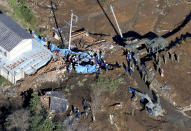 Rescuers work at a landslide site hit by Typhoon Hagibis, in Tomioka, north of Tokyo, Sunday, Oct. 13, 2019. Rescue efforts for people stranded in flooded areas are in full force after a powerful typhoon dashed heavy rainfall and winds through a widespread area of Japan, including Tokyo.(Yohei Kanasahi/Kyodo News via AP)