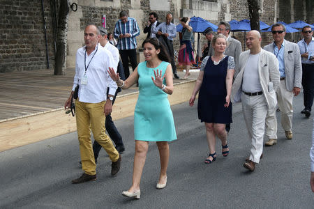 Paris Mayor Anne Hidalgo (C) walks on the banks of the river Seine on the opening day of the Paris Plages beach festival in Paris, France, six days after a truck driver killed 84 people when he mowed through a crowd on the French Riviera, July 20, 2016. REUTERS/Charles Platiau