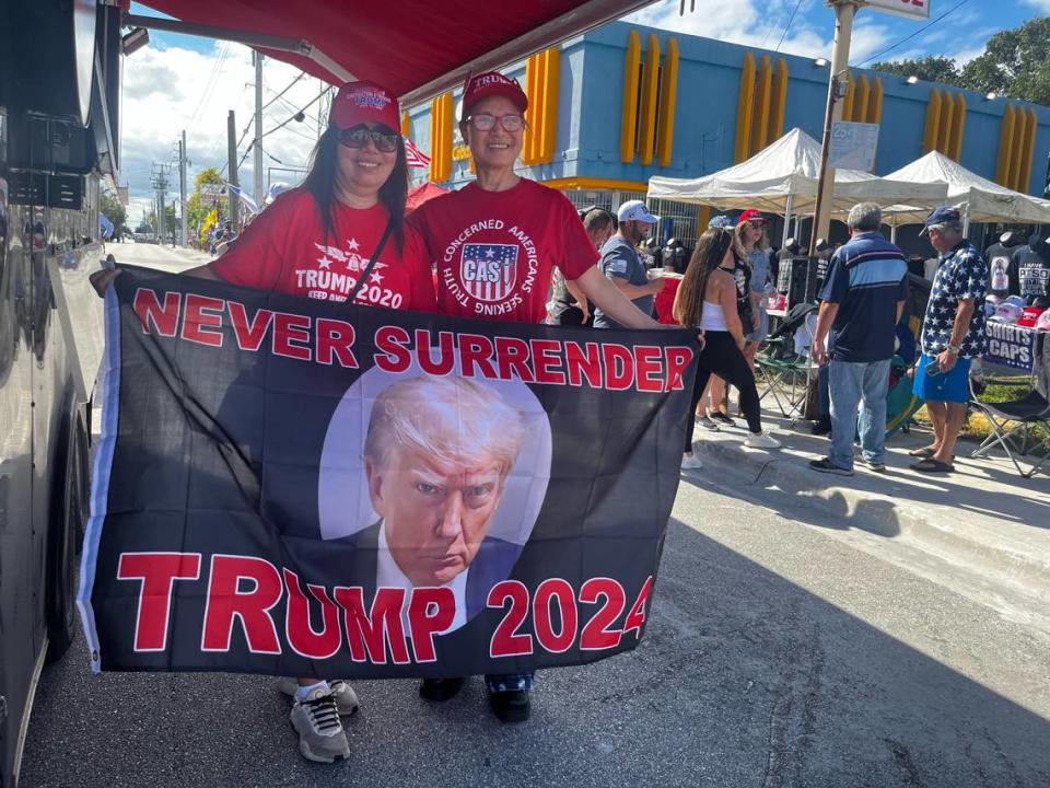 Grace Becker, left, and Hao Hao, 64, hold up a Trump 2024 flag as they await the former president’s rally in Hialeah on Wednesday, November 8, 2023.