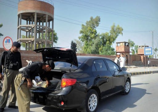 Pakistani policemen search a vehicle in front of the Peshawar central jail where Pakistani surgeon Shakeel Afridi, who worked for US intelligence, was moved after being sentenced to 33 years for treason