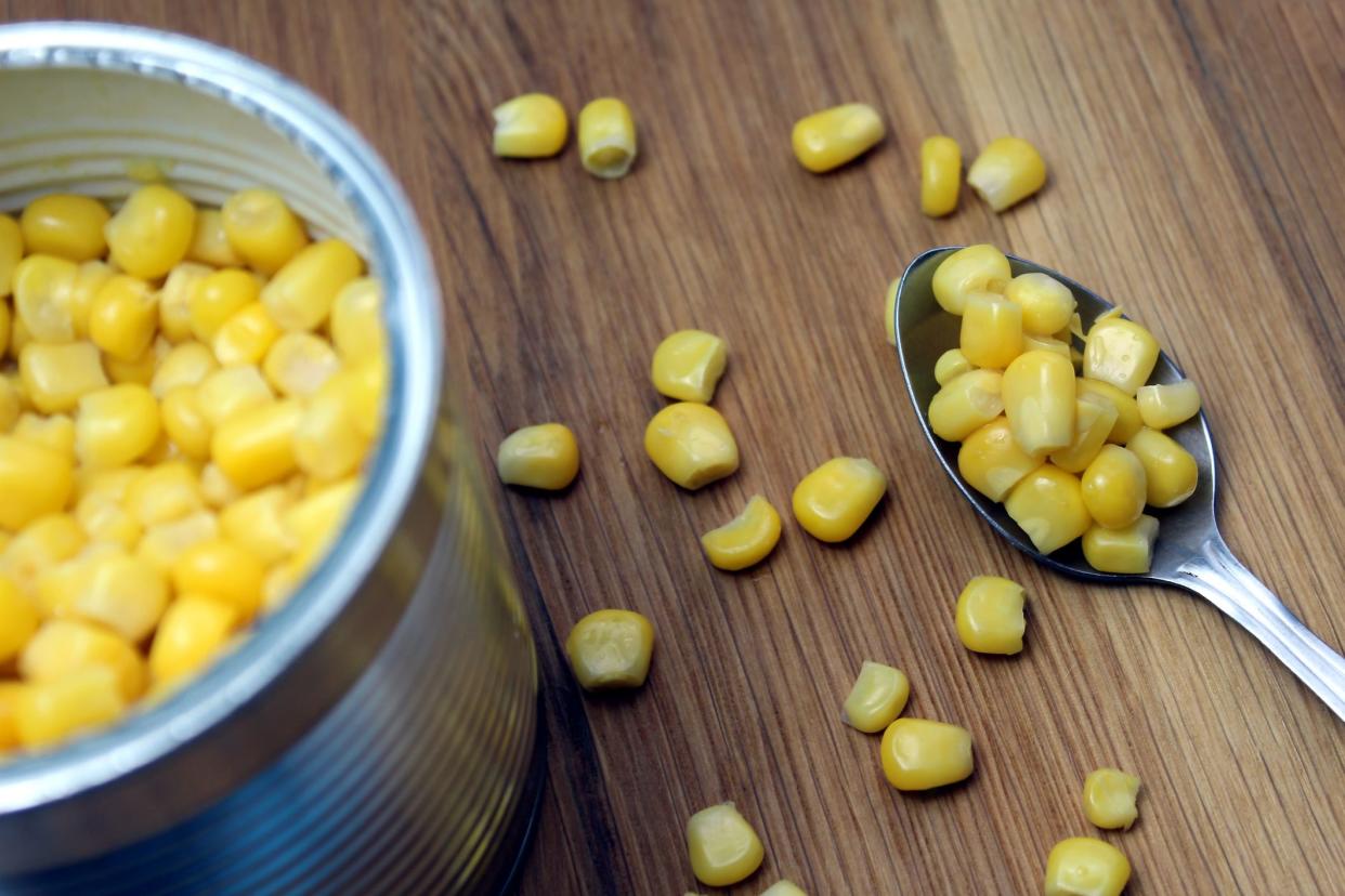 Canned corn with a spoon on the table