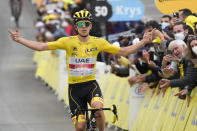 Slovenia's Tadej Pogacar, wearing the overall leader's yellow jersey, celebrates as he crosses the finish line to win the eighteenth stage of the Tour de France cycling race over 129.7 kilometers (80.6 miles) with start in Pau and finish in Luz Ardiden, France,Thursday, July 15, 2021. (AP Photo/Christophe Ena)