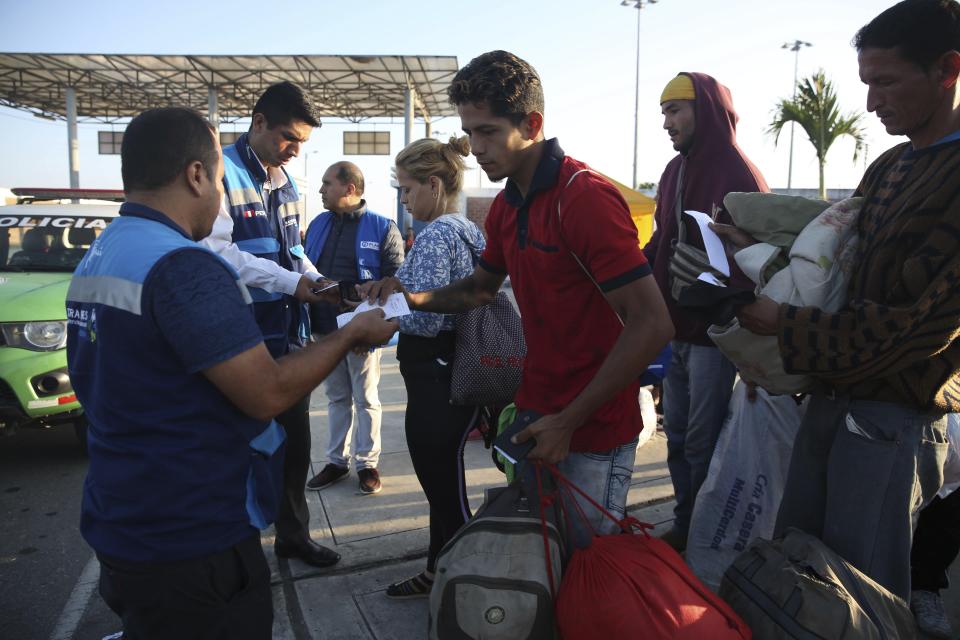 Peruvian migration officers check documents of Venezuelan migrants after stricter entry requirements went into effect, in Tumbes, Peru, Saturday, June 15, 2019. With its relatively stable economy and flexible immigration laws, Peru has become a main destination for millions of Venezuelans escaping hyperinflation, medical shortages and political repression at home. (AP Photo/Martin Mejia)