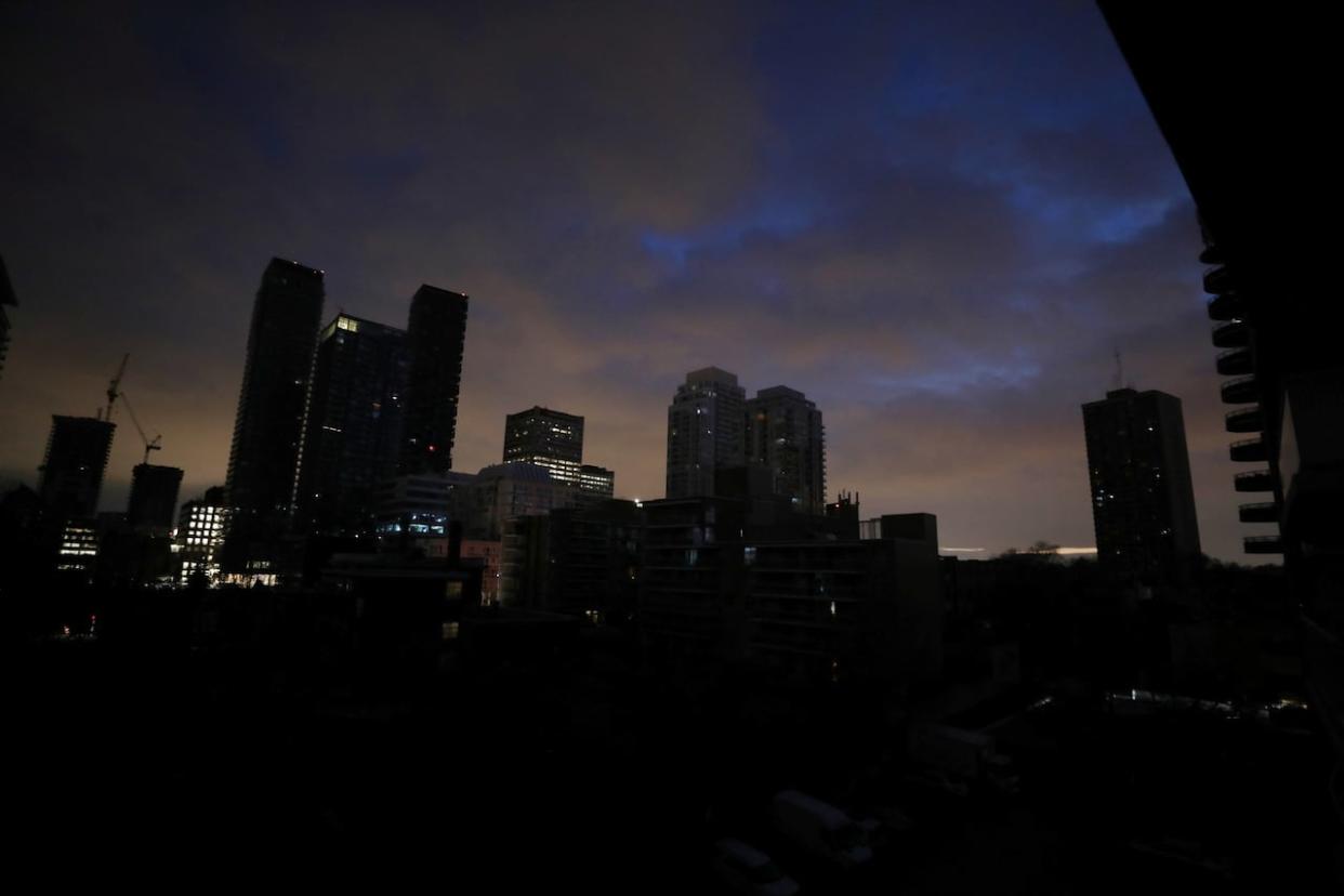 Blacked-out residential buildings are silhouetted against the sky during an electrical power outage in midtown Toronto on Jan. 6, 2023.    (Chris Helgren/Reuters - image credit)