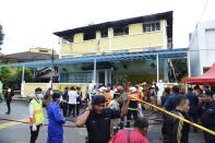 <p>Police and rescue personnel work at an Islamic religious school cordoned off after a fire on the outskirts of Kuala Lumpur Thursday, Sept. 14, 2017. A fire department official in Malaysia said a fire at the Islamic religious school has killed people, mostly teenagers. (Photo: AP) </p>