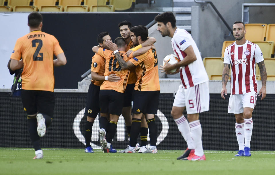 El mexicano Raúl Jiménez es felicitado por sus compañeros del Wolverhampton Wanderers luego de anotar el primer gol de su equipo por la vía del penal en el duelo de vuelta de los octavos de final de la Liga de Europa ante el Olympiakos, el jueves 6 de agosto de 2020, en Wolverhampton, Inglaterra. (AP Foto/Rui Vieira)