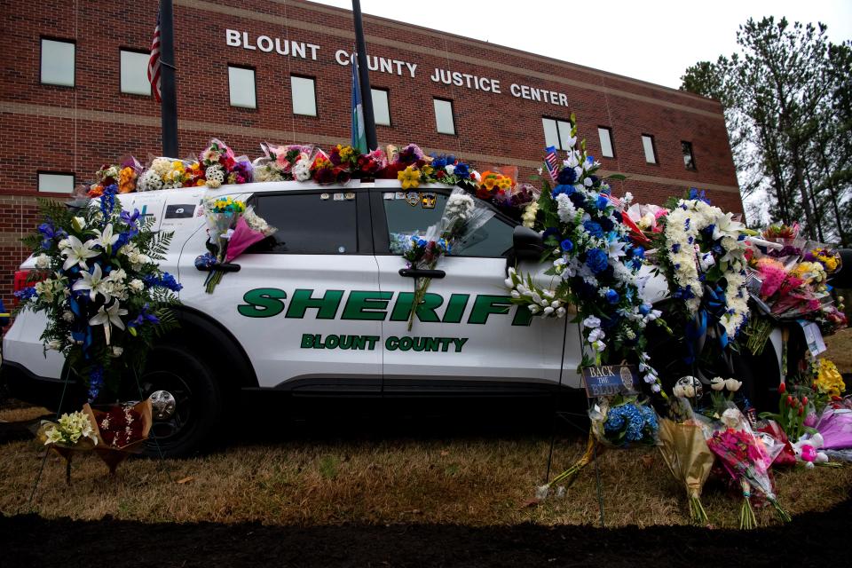 Flowers cover the Blount County Sheriff's Office patrol car used by Greg McCowan, who was shot and killed last week.