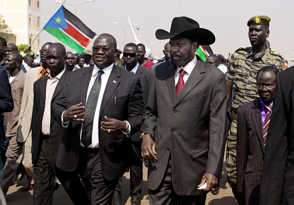 FILE - In this Tuesday, Feb. 8, 2011 file photo, South Sudanese President Salva Kiir, centre-right, is greeted by then Vice-President Riek Machar, centre-left, on Kiir's return from Khartoum where he attended the formal announcement of southern Sudan's referendum results. A spokesman for South Sudan's president said Wednesday, Jan. 29, 2014 that seven of the 11 leaders accused of plotting a failed military coup in December, whom the commander of rebel forces former Vice-President Riek Machar has repeatedly demanded be freed, have been flown to Kenya where they will still be held in custody. (AP Photo/Pete Muller, File)