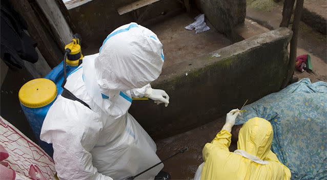 Health workers in protective equipment take a sample from the body of someone who is suspected to have died from Ebola virus, near Rokupa Hospital, Freetown. Photo: REUTERS/Christopher Black/WHO