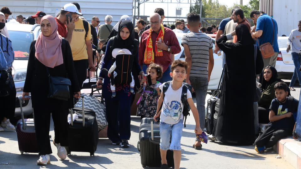 Palestinians wait at the Rafah border crossing. - Hatem Ali/AP