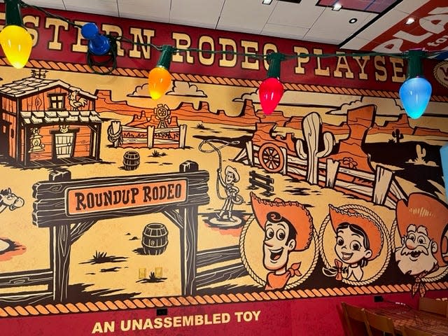 The box cover of a Western Rodeo Playset covers one wall and pieces of the playset can be seen around the restaurant.