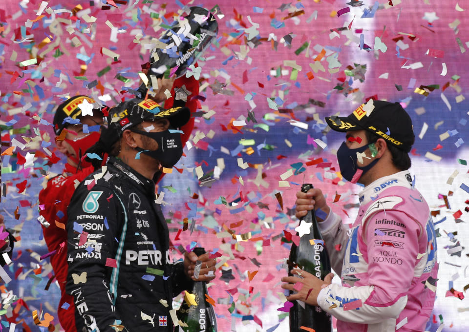 El tercer sitio, el alemán Sebastian Vettel de la escudería Ferrari, (izquierda) rocía con champaña al ganador, el británico Lewis Hamilton de Mercedes mientras el piloto de Racing Point, Sergio Pérez, de México y quien terminó en segundo sitio, los observa luego del Gran Premio de Turquía en el circuito de Estambul, el domingo 15 de noviembre de 2020. (AP Foto/Kenan Asyali, Pool)