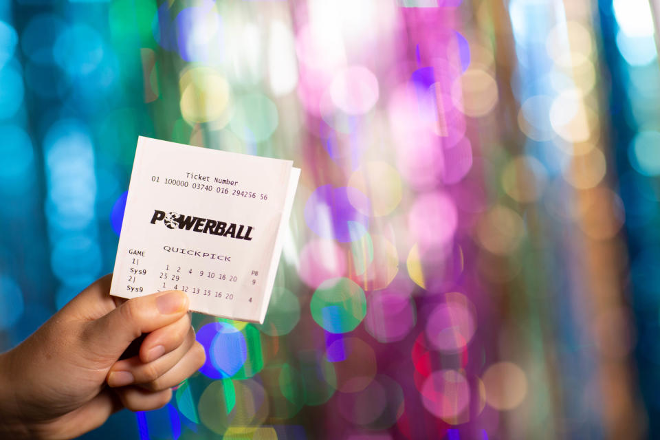 A Powerball ticket in front of streamers. Source: The Lott