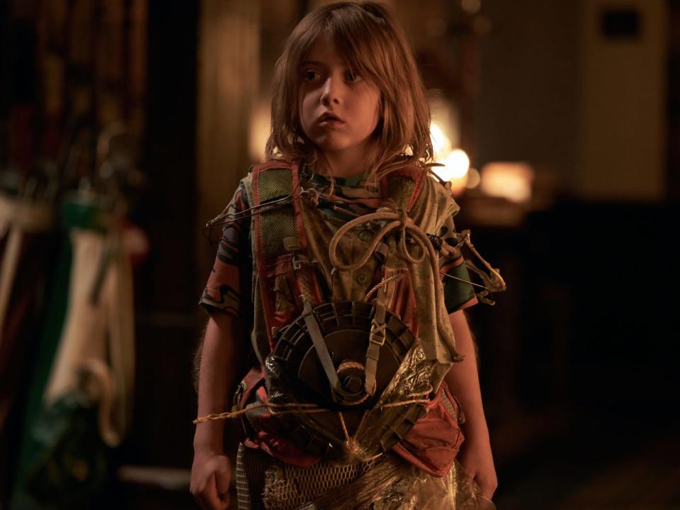 a disheveled child stands with a bunch of wires and an explosive device strapped to their chest in station eleven