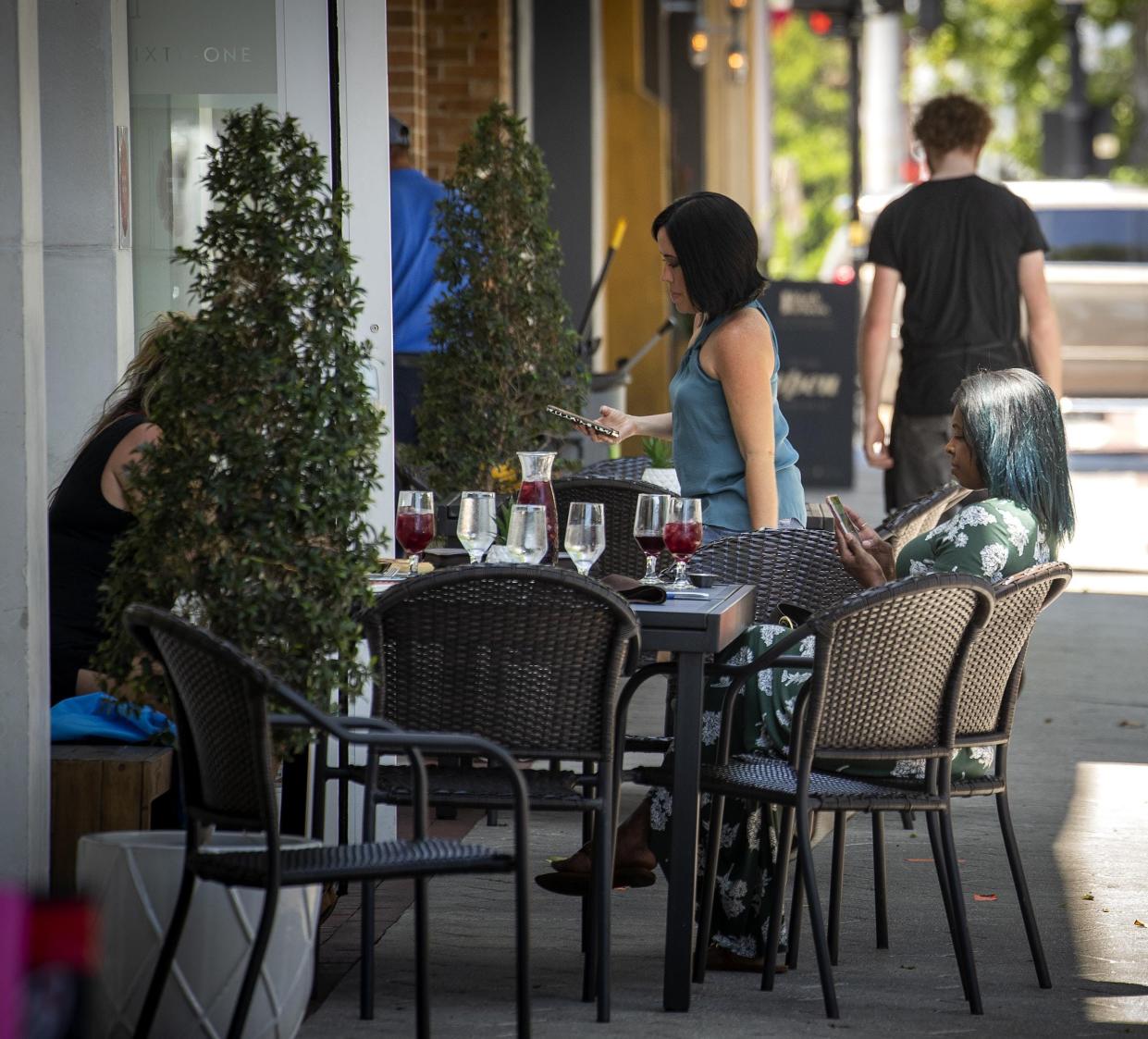 Downtown lunch goers enjoy a meal outside the Nineteen61 restaurant in Lakeland.