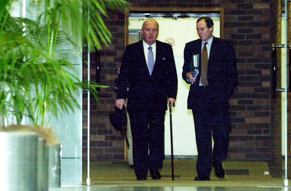 The radio announcer is pictured walking out of the Supreme Court with the aid of a walking stick. Photo: AAP