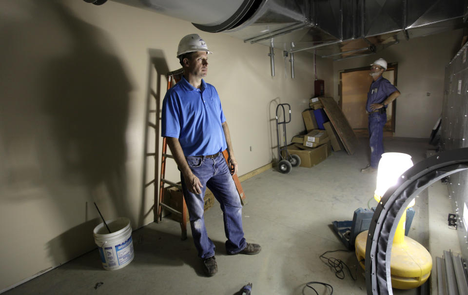 In this Tuesday, June 19, 2012 photo, electrical contractor Howie Drees inspects some newly-installed equipment on a job site in Carroll, Iowa. Drees, a third-generation contractor, gauges prosperity by his crowded work calendar. These days, he's so busy with mechanical and electrical projects he's hired an outside company to help and is searching for skilled workers. (AP Photo/Charlie Neibergall)